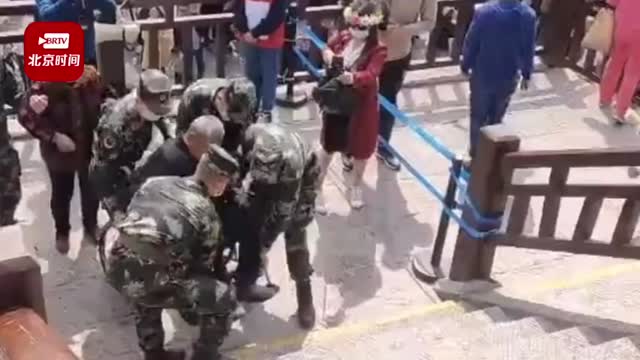 武警官兵抬着轮椅老人游览龙门石窟